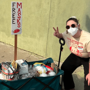 MR Online | Mask Bloc LA member Abby Mahler poses with a wagon full of free high quality masks Image via Abby Mahler | MR Online